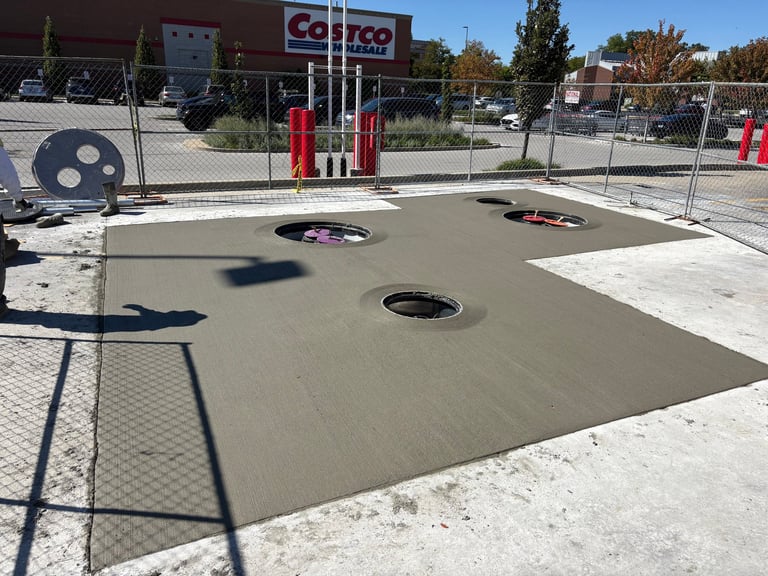 Cornhole game setup in outdoor court with multiple bean bag toss boards and holes, fence surrounding area, Costco storefront visible in background